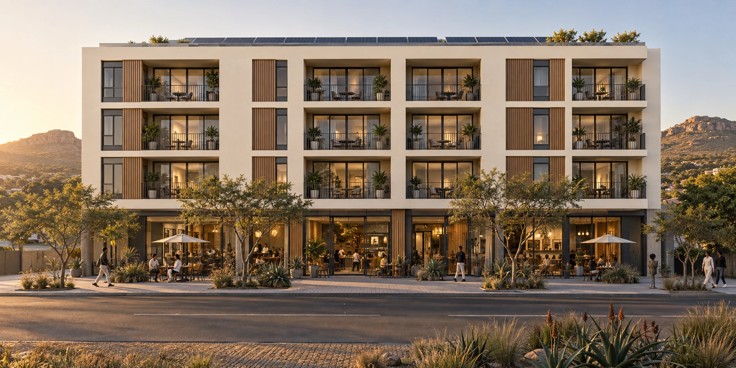 Precast apartments on three floors above a glazed ground-floor café and shops at golden hour.